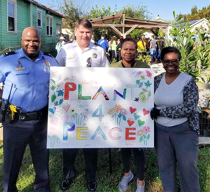 Miembros de la Asociación de Vecinos de Bunny Friend publicando con un cartel que dice &quot;Plan para la Paz&quot;